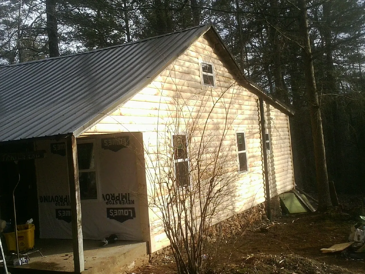 Log siding gable end under a dark metal roof edge in Unionville
